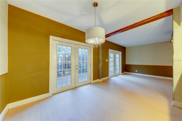 spare room with wood-type flooring, french doors, a notable chandelier, and beam ceiling