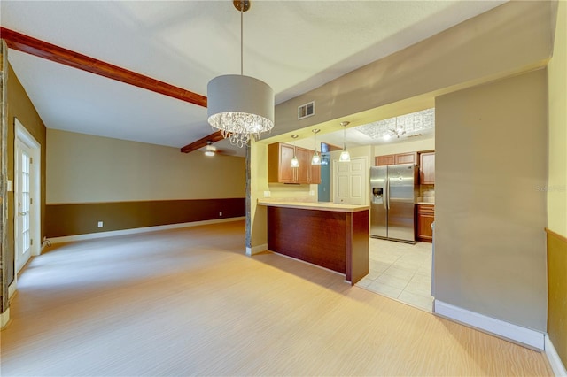 kitchen featuring kitchen peninsula, stainless steel fridge, light tile patterned floors, decorative light fixtures, and a notable chandelier