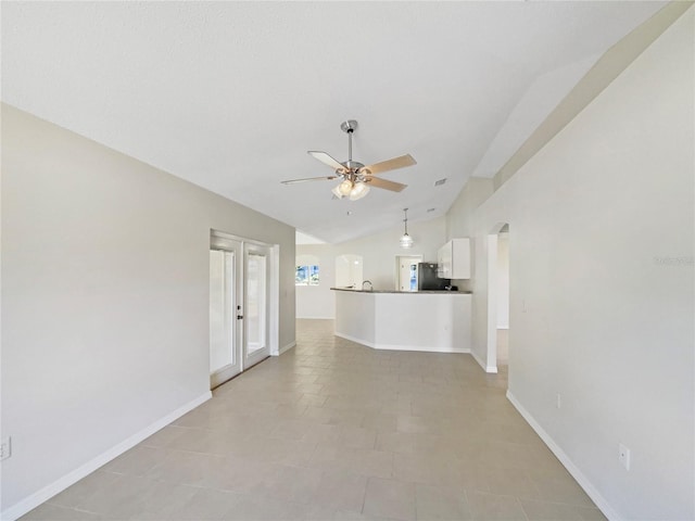 unfurnished living room with ceiling fan, light tile patterned flooring, and lofted ceiling