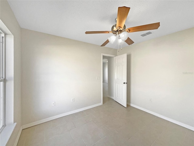 tiled spare room featuring a textured ceiling