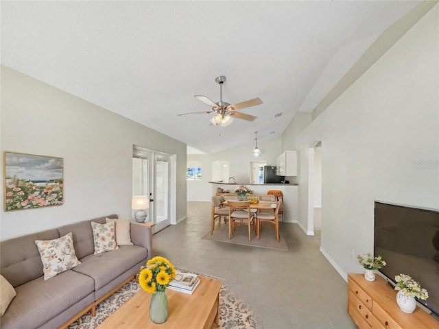 tiled living room featuring ceiling fan and lofted ceiling