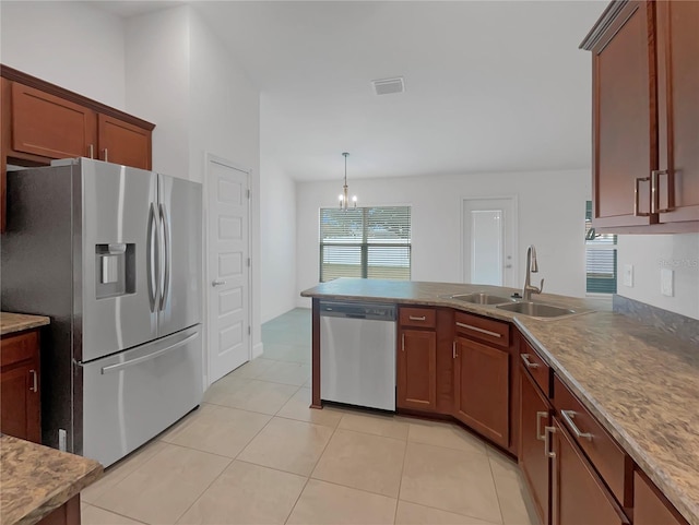 kitchen featuring stainless steel appliances, sink, light tile patterned floors, a notable chandelier, and hanging light fixtures