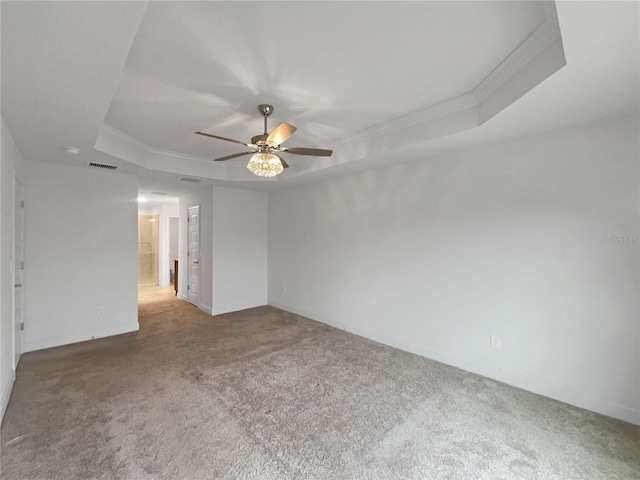 spare room with a raised ceiling, ceiling fan, carpet flooring, and crown molding