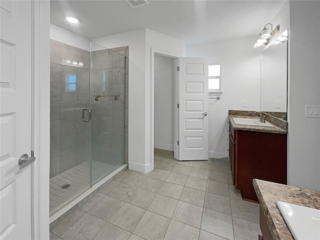 bathroom featuring a shower with door, vanity, and tile patterned flooring