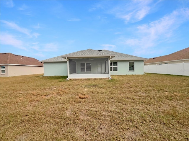 back of property featuring a yard and a sunroom