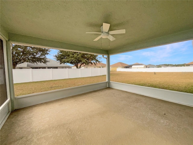 unfurnished sunroom featuring ceiling fan