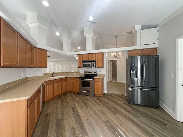 kitchen featuring sink, dark wood-type flooring, a notable chandelier, kitchen peninsula, and appliances with stainless steel finishes