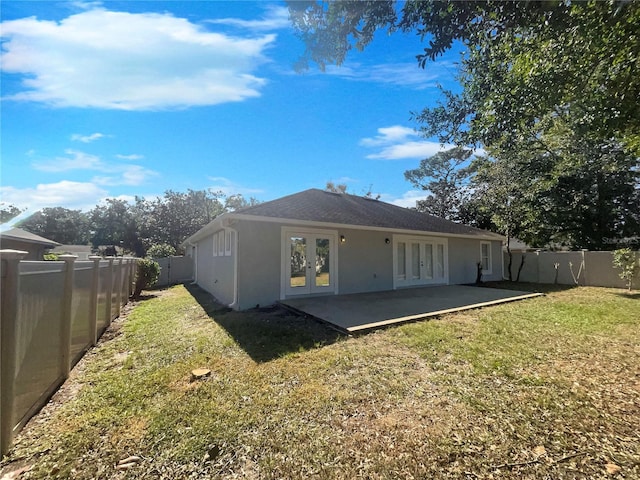 back of house with a yard, french doors, and a patio