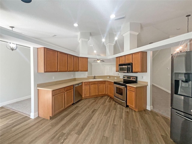 kitchen featuring sink, hanging light fixtures, crown molding, vaulted ceiling, and appliances with stainless steel finishes