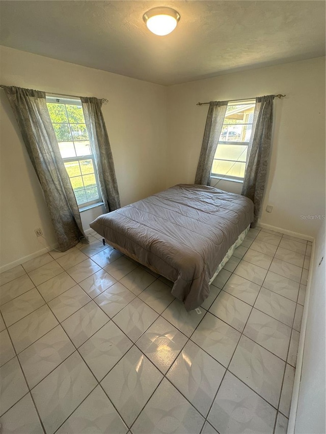 tiled bedroom featuring multiple windows