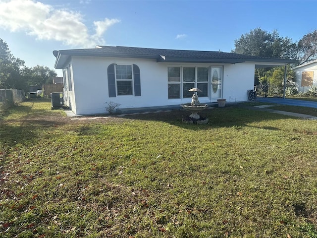 back of house with central air condition unit and a yard