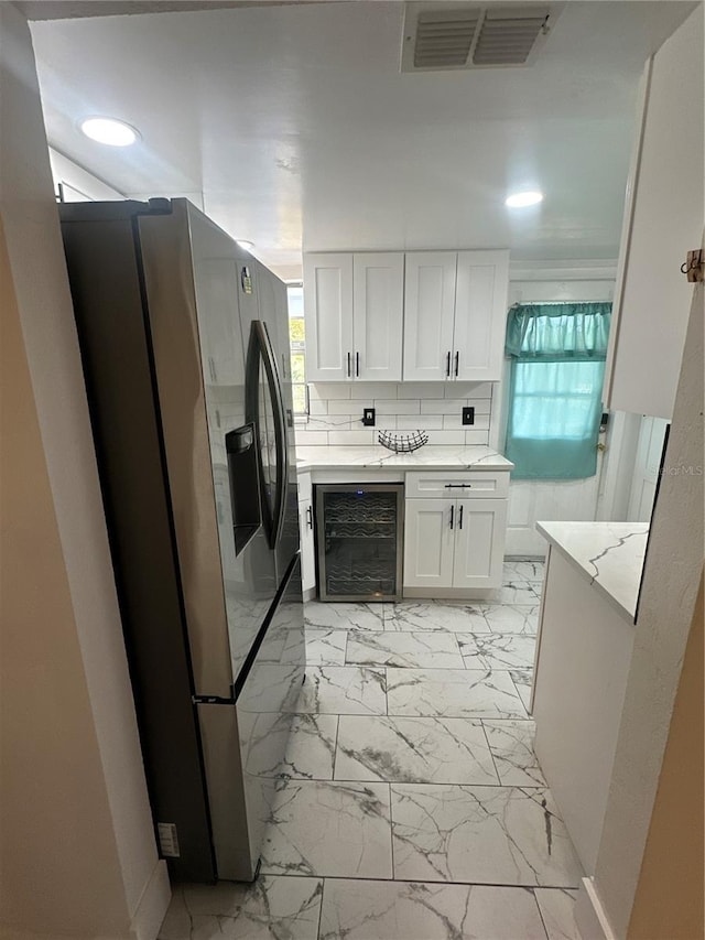 kitchen with white cabinets, decorative backsplash, wine cooler, and stainless steel fridge with ice dispenser