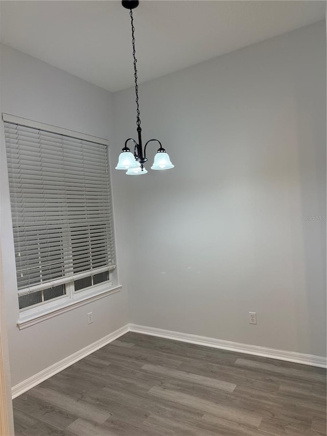 unfurnished dining area with a chandelier and dark wood-type flooring