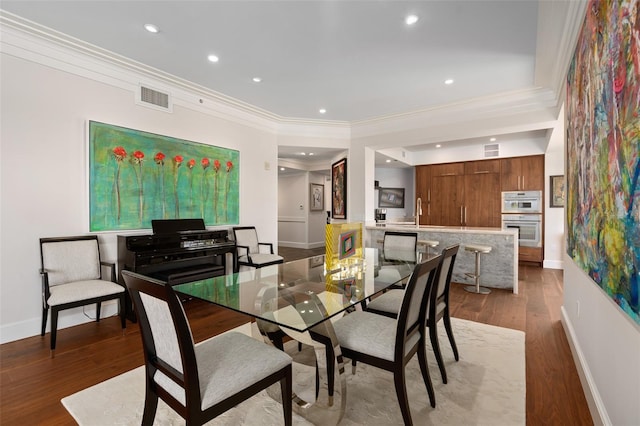 dining area featuring crown molding, recessed lighting, wood finished floors, and visible vents