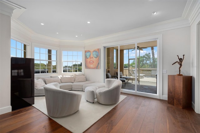 living room featuring baseboards, hardwood / wood-style floors, and ornamental molding