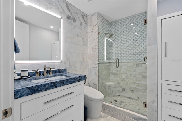 bathroom featuring tile walls, a shower stall, toilet, and vanity