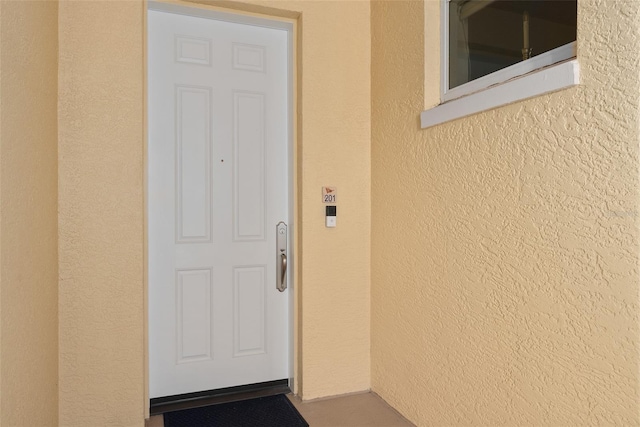 entrance to property with stucco siding