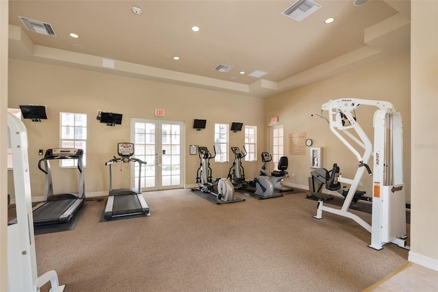 workout area with a tray ceiling, french doors, visible vents, and recessed lighting