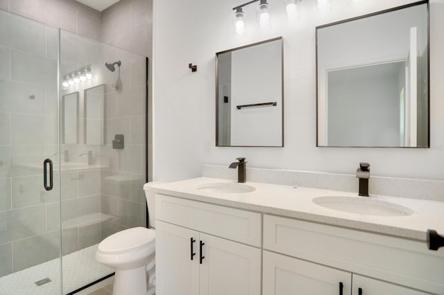 bathroom with vanity, toilet, and a shower with shower door