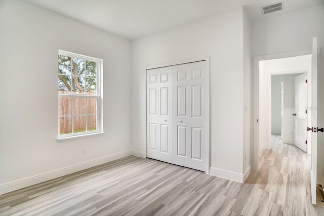 unfurnished bedroom with light hardwood / wood-style floors and a closet