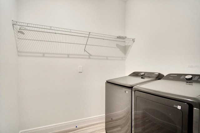 washroom with washer and clothes dryer and wood-type flooring