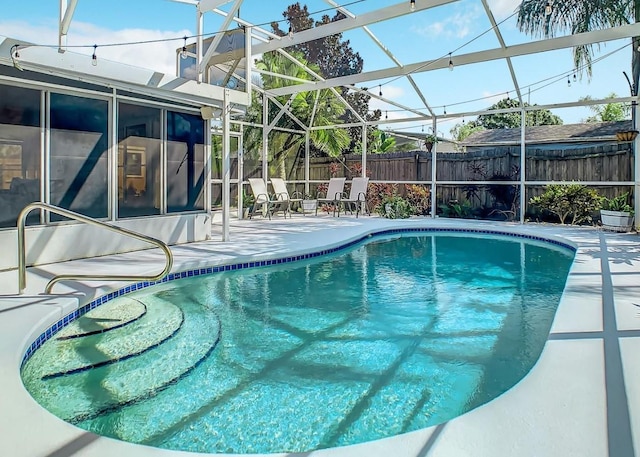 view of swimming pool featuring glass enclosure and a patio area