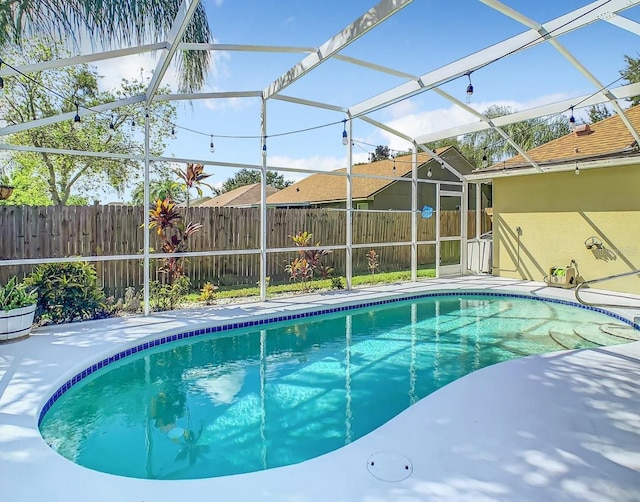 view of swimming pool with a lanai and a patio area