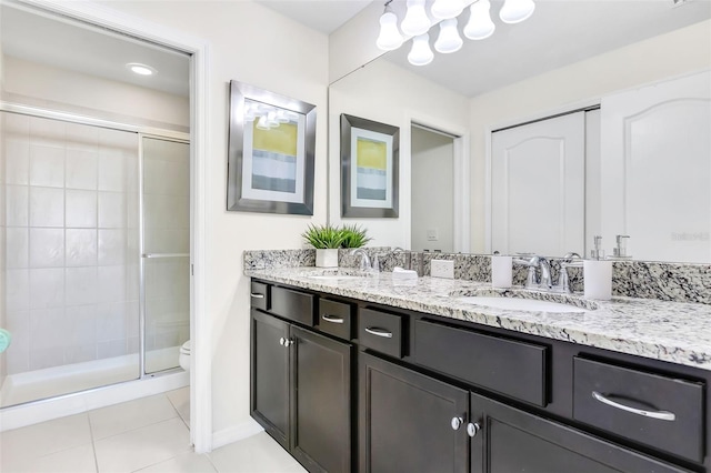 bathroom with tile patterned flooring, vanity, toilet, and a shower with shower door