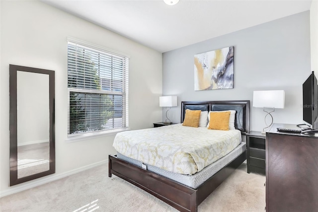 bedroom featuring multiple windows and light carpet