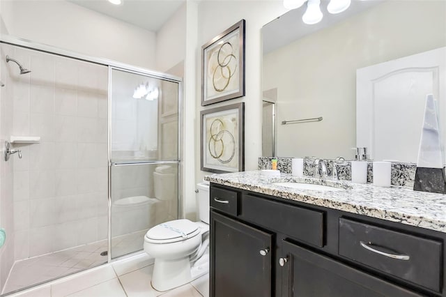 bathroom featuring toilet, vanity, tile patterned floors, and an enclosed shower