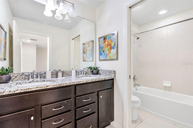 full bathroom with tiled shower / bath combo, tile patterned flooring, a notable chandelier, toilet, and vanity