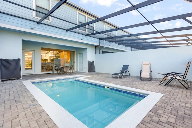 view of swimming pool with glass enclosure and a patio