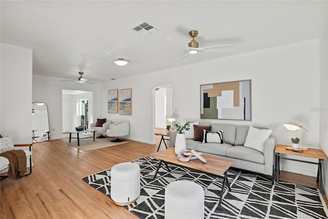 living room featuring wood-type flooring and ceiling fan