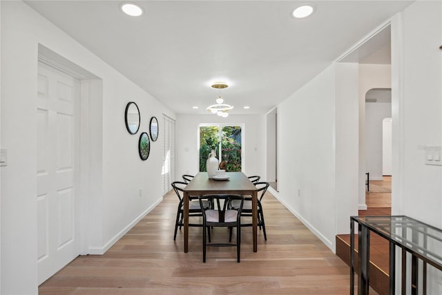 dining space featuring an inviting chandelier and light hardwood / wood-style floors