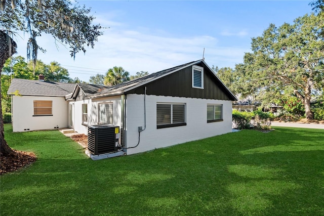 back of house with central AC and a lawn