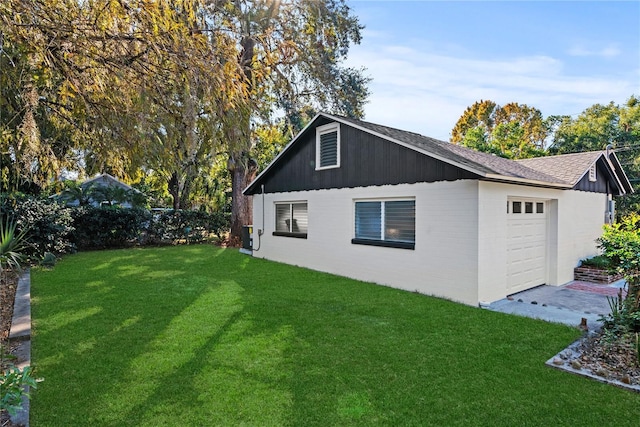 view of side of home with a yard and a garage