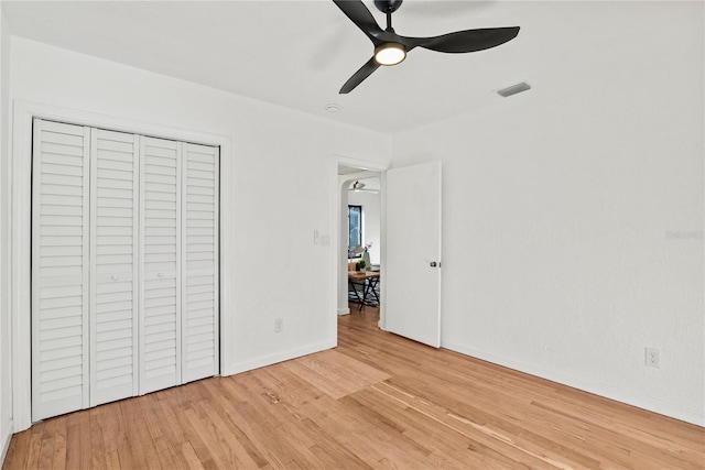 unfurnished bedroom featuring light hardwood / wood-style flooring, a closet, and ceiling fan