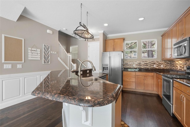 kitchen featuring sink, hanging light fixtures, stainless steel appliances, dark hardwood / wood-style flooring, and a kitchen island with sink