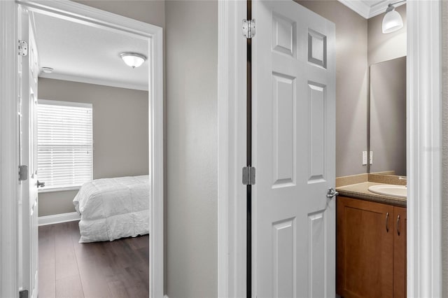 bathroom featuring hardwood / wood-style flooring, vanity, ornamental molding, and a textured ceiling