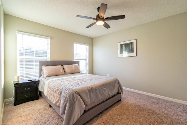 carpeted bedroom featuring ceiling fan and a textured ceiling