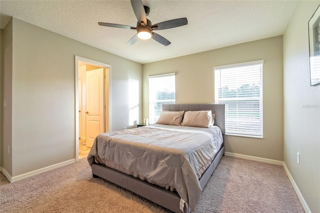 carpeted bedroom featuring ceiling fan, ensuite bathroom, and a textured ceiling