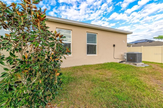 rear view of property with a yard and central AC