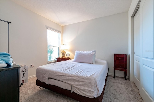 carpeted bedroom with a closet and a textured ceiling