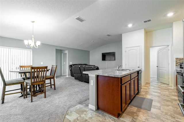 kitchen featuring pendant lighting, lofted ceiling, a kitchen island with sink, sink, and light colored carpet