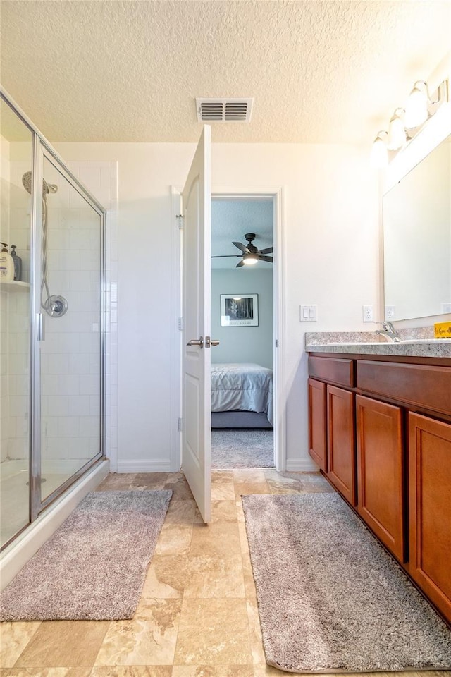 bathroom with vanity, a textured ceiling, an enclosed shower, and ceiling fan