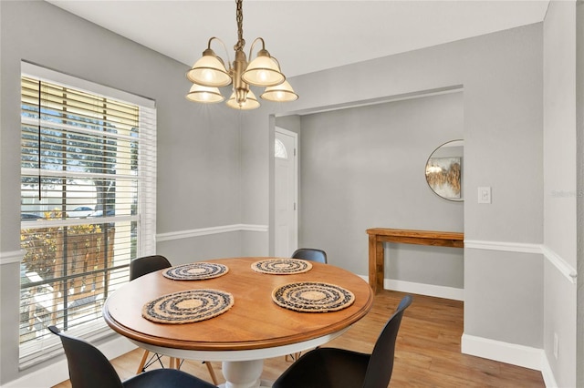 dining room with light hardwood / wood-style floors and an inviting chandelier