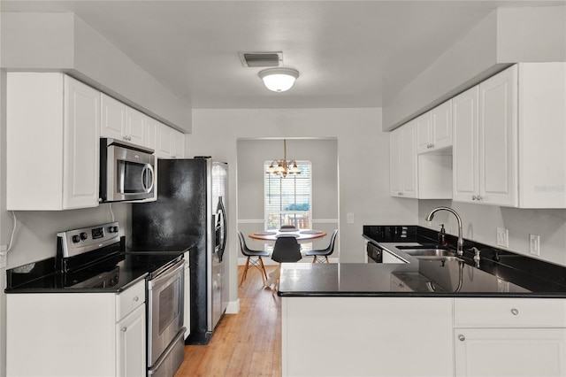 kitchen featuring appliances with stainless steel finishes, sink, a notable chandelier, light hardwood / wood-style floors, and white cabinetry