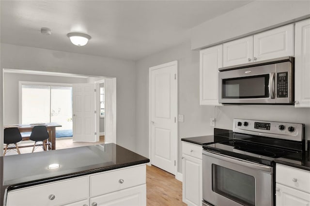 kitchen with white cabinets, stainless steel appliances, and light hardwood / wood-style floors