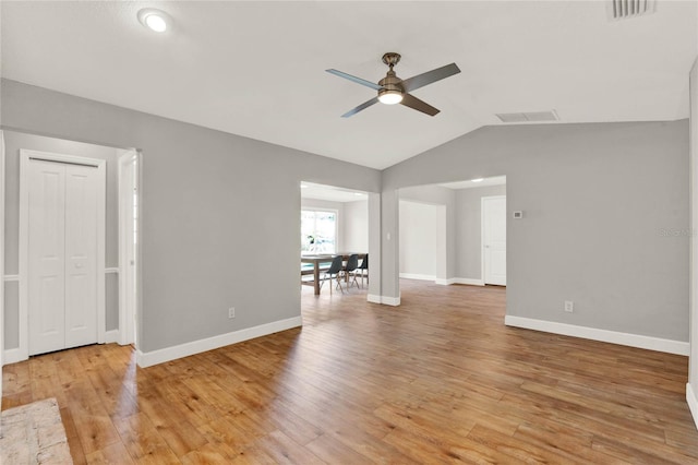 empty room with ceiling fan, lofted ceiling, and light wood-type flooring