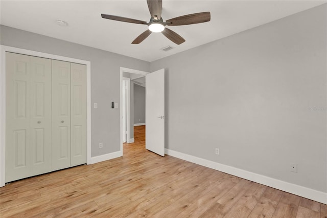 unfurnished bedroom with ceiling fan, light hardwood / wood-style floors, and a closet